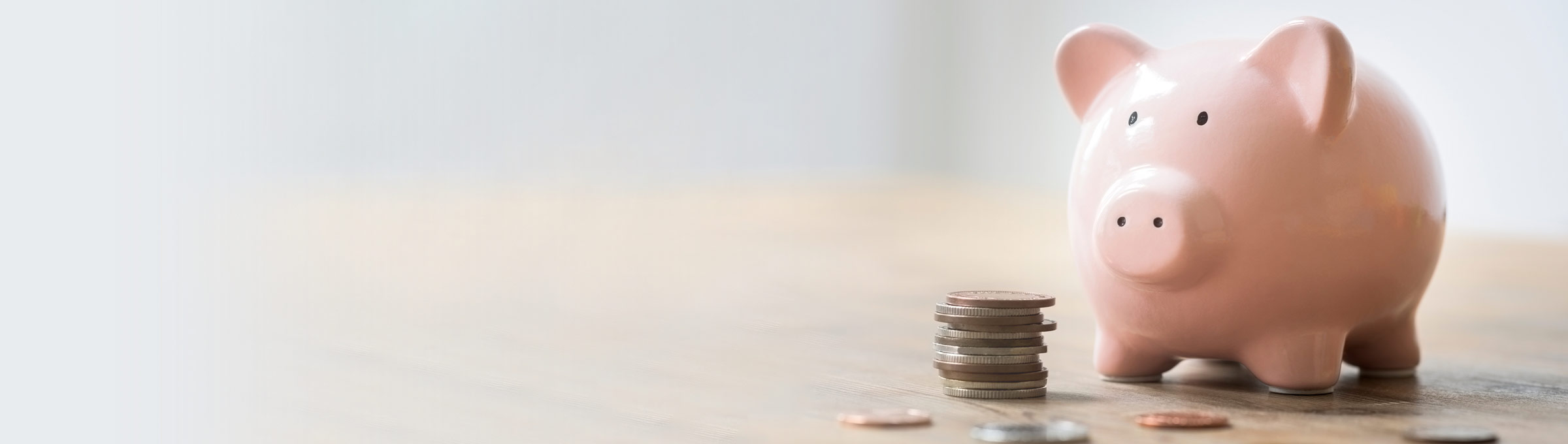 Piggy bank and coins sitting on table