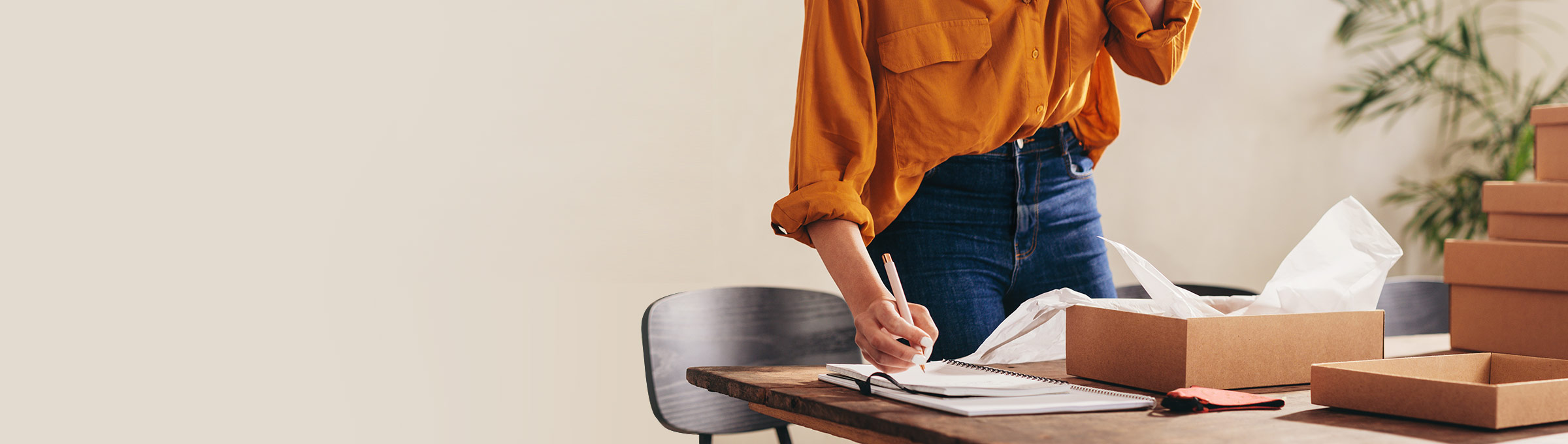 Woman writing in notebook on desk.